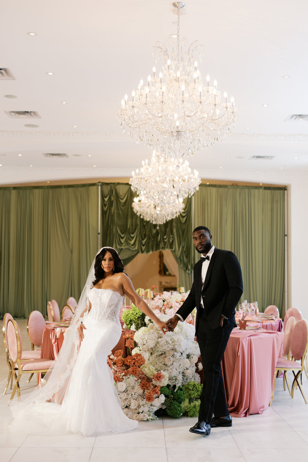 Bride and groom holding hands in an elegant reception hall